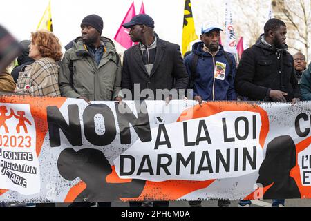 Parigi, Francia. 25th Mar, 2023. I manifestanti hanno una bandiera che esprime la loro opinione durante una manifestazione contro la legge di Darmanin. Migliaia di migranti francesi e non documentati hanno marciato contro il disegno di legge del ministro degli interni francese Gerald Darmanin, che intende limitare ulteriormente il diritto di asilo, di precarietà e di criminalizzazione degli immigrati e aumentare la quota di manodopera che può essere costretta a lavorare e deportata a volontà. (Foto di Telmo Pinto/SOPA Images/Sipa USA) Credit: Sipa USA/Alamy Live News Foto Stock