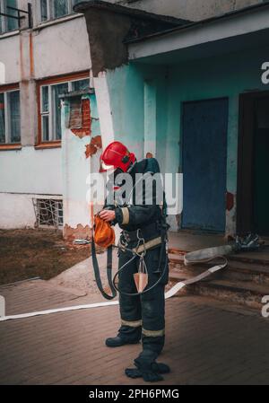 uomo vigile del fuoco che si prepara a spegnere le munizioni antincendio Foto Stock