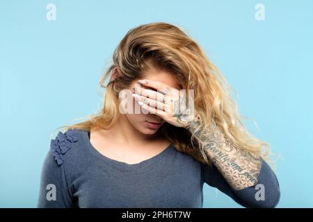 facepalm emozione di vergogna rovesciato faccia della copertura della ragazza Foto Stock