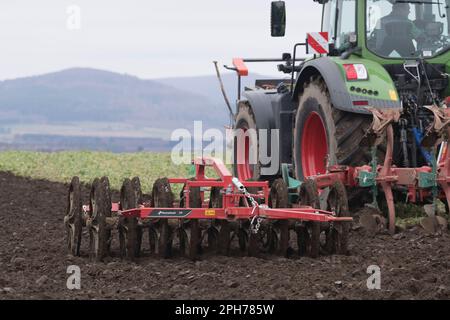 Un Kverneland DP (Double Trailed Soil Packer) che viene trainato insieme a un aratro reversibile da un trattore Fendt in un campo arato Foto Stock