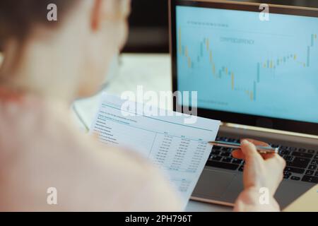 Primo piano su una moderna donna d'affari con un notebook che investe in criptovalute in uffici moderni. Foto Stock
