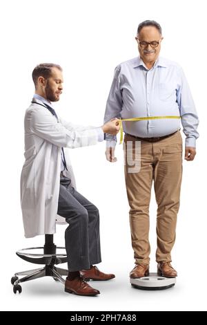 Medico che prende le misure della vita da un uomo maturo isolato su sfondo bianco Foto Stock