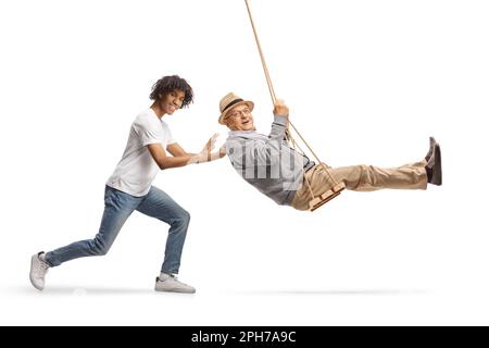 Giovane afro-americano che spinge un anziano su un altalena isolato su sfondo bianco Foto Stock
