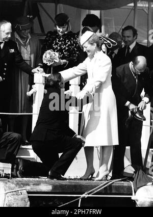 AJAXNETPHOTO. 26TH MARZO, 1982. COWES, INGHILTERRA. - LANCIO DEGLI YACHT AMERICA'S CUP - H.R.H. LA PRINCIPESSA MICHAEL DEL KENT È STATA AIUTATA GRAZIOSAMENTE A RIVA E NELLE SUE SCARPE DOPO UN TOUR A PIEDI NUDI DELLO YACHT CHE AVEVA APPENA CHIAMATO, MENTRE IL BANCHIERE MERCANTILE PETER DE SAVARY (A DESTRA) PROPRIETARIO DELLA VITTORIA FUMA CON I SUOI BROGUES. LA PRINCIPESSA SEMBRA TROVARE DIVERTENTE LA SITUAZIONE DI MR DE SAVARY. FOTO:JONATHAN EASTLAND/AJAX RIF:222904 MX340 18 (VEDERE ANCHE 222904 MX340 17 & 19) Foto Stock