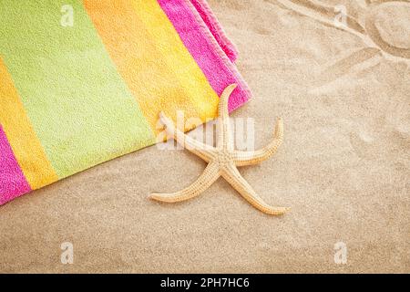 Asciugamano da spiaggia e stelle marine sulla spiaggia in estate. Foto Stock