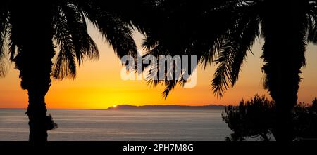 Tramonto dietro l'isola di Santa Catalina al largo della costa dell'Oceano Pacifico di Dana Point, Orange County, California meridionale Foto Stock