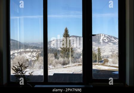 Vista sulle montagne innevate dalla grande finestra in Ucraina Foto Stock