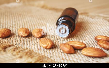 Olio essenziale di mandorla in una piccola bottiglia. Messa a fuoco selettiva. Foto Stock
