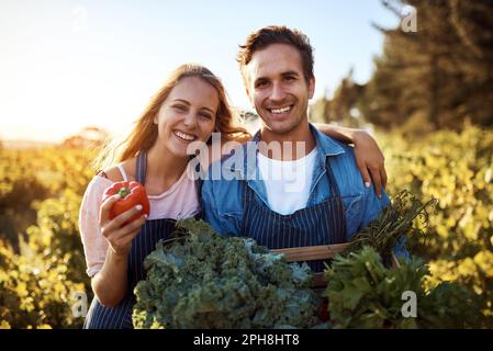 Sembrano buoni e hanno un sapore ancora migliore. Ritratto corto di una giovane coppia affettuosa che lavora insieme in una fattoria. Foto Stock