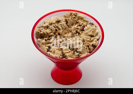 Ciotola rossa di gelato alla nocciolata italiana. Gelato con diversi tipi di nocciola. Foto Stock