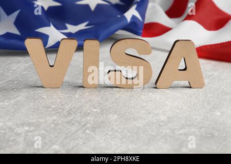 Word Visa e American flag sulla tabella grigio chiaro, spazio per il testo Foto Stock