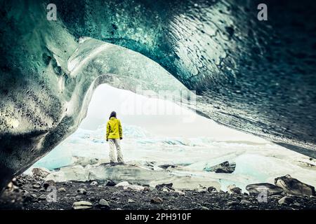 Vista panoramica del turista dal ghiacciaio Fjallsjökull in Islanda dall'interno della grotta del ghiacciaio. Esplora le gemme nascoste dell'Islanda. Famoso trave Foto Stock