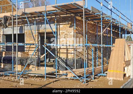 Costruzione di edifici salute e sicurezza tramite ponteggi ad accesso indipendente con ponteggi tubolari rinforzati diagonalmente in tavole di punta corrimano per il corpo nel Regno Unito Foto Stock