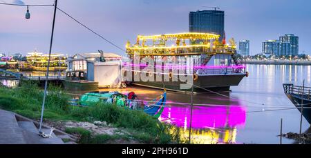 Colorato illuminato al crepuscolo, sulla zona Riverside di Phnom Penh, utilizzato come locali notturni per i turisti, mangiare, bere e ballare, durante il tour, luminoso, a Foto Stock