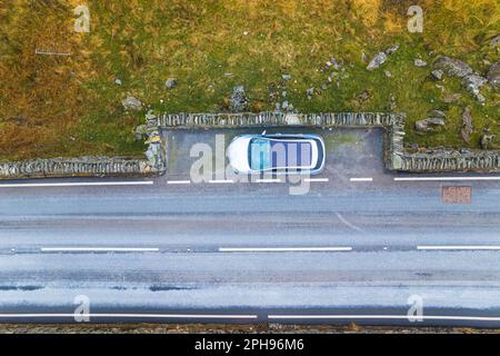 Auto moderna parcheggiata una fermata di parcheggio durante un viaggio attraverso le montagne. Turismo automobilistico. Vista dall'alto. Ripresa aerea del drone. Foto di alta qualità Foto Stock