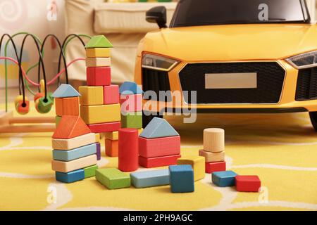 Edifici colorati e auto elettrica per bambini sul pavimento nella sala giochi Foto Stock