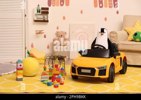 Auto elettrica per bambini e altri giocattoli in sala giochi Foto Stock