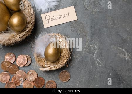 Molte uova d'oro, monete e carta con parola pensionamento su tavolo grigio, piatto. Concetto di pensione Foto Stock