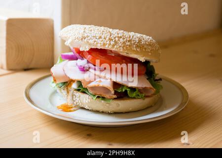 Delizioso panino di tacchino su pane in bagel. Un bagel è un pane tradizionalmente fatto di farina di grano e di solito ha un buco al centro. Foto Stock