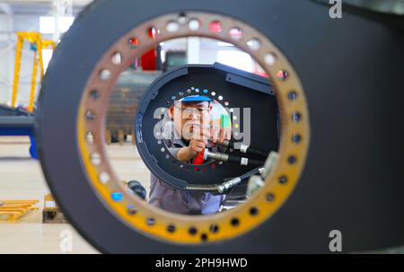 LIANYUNGANG, CINA - 27 MARZO 2023 - Un lavoratore assembla parti di un escavatore in un'officina di produzione di Luyou Heavy Industry Co LTD a Lianyungang, Foto Stock