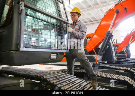 LIANYUNGANG, CINA - 27 MARZO 2023 - Un lavoratore assembla un escavatore ad un'officina di Luyou Heavy Industry Co LTD a Lianyungang, Jiangs della Cina orientale Foto Stock