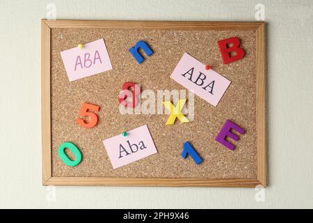 Concetto di analisi del comportamento applicato. Note cartacee con l'abbreviazione ABA, lettere e numeri colorati sul pannello a corkboard Foto Stock