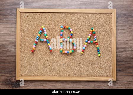 Concetto di analisi del comportamento applicato. Corkboard con abbreviazione ABA fatto di pin colorati su tavolo di legno, vista dall'alto Foto Stock