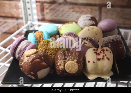 Vetrina con deliziosi macaron colorati sullo scaffale in caffetteria Foto Stock