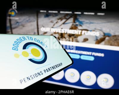 Cellulare con il logo della British Border to Coast Pensions Partnership sullo schermo di fronte al sito web aziendale. Messa a fuoco sul lato destro del display del telefono. Foto Stock