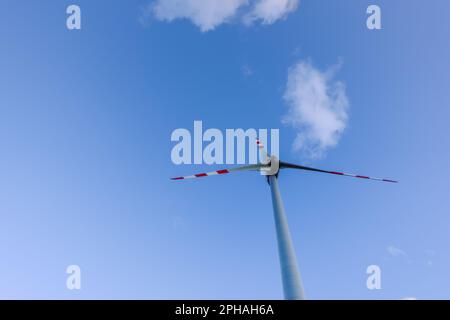 mulino a vento singolo alto e nuvole morbide sul cielo blu per un'energia pulita Foto Stock