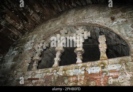 Alun, Contea di Hunedoara, Romania, 2003. All'interno della chiesa cristiana ortodossa in legno abbandonata, monumento storico del 17th ° secolo. Primo piano della parte superiore dell'iconostasi, con vista sulle antiche murales e cinque croci lignee. Foto Stock