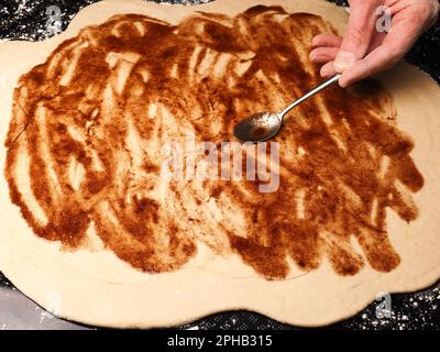 Spalmabili in panettiere o in cottura, impasti di lievito biologico con miscela di cannella e zucchero, lavorazione tradizionale in cucina Foto Stock