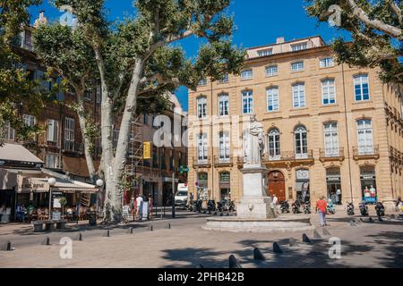 Aix-en-Provence, una città vibrante con la sua splendida architettura, le strade urbane e le piazze del quartiere fiancheggiate da alberi. Un gruppo di persone si è riunito alla statua di Roi René in questa pittoresca piazza della città. Foto Stock