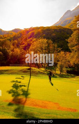 Golfista mettere sul campo da golf Menaggio con Mountain View in autunno in Lombardia. Foto Stock