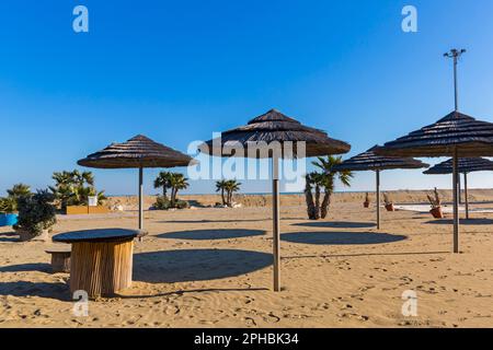 Ombrelloni e ombre sulla spiaggia di Blue Moon, Lido di Venezia, Lido Island, Venezia, Italia a febbraio Foto Stock