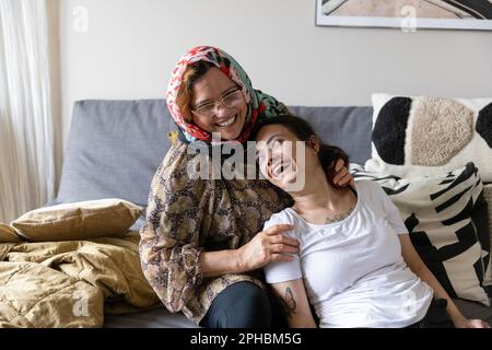 Figlia felice con paraplegia trascorrere il tempo libero con la madre a casa Foto Stock