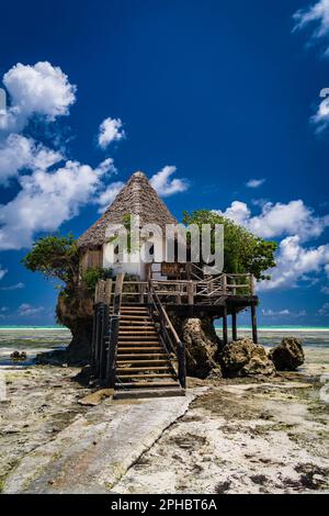 Un idilliaco scenario spiaggia caratterizzato da una casa pittoresca, e la vasta distesa dell'oceano sullo sfondo Foto Stock