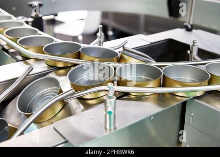 Lattine vuote sul trasportatore di una fabbrica di prodotti alimentari Foto Stock