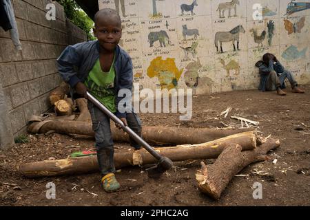 Arusha, Tanzania - 17th ottobre 2022: Un ragazzo che divide il legno nella fruttuosa Orfanotrofio di Arusha, Tanzania. Foto Stock