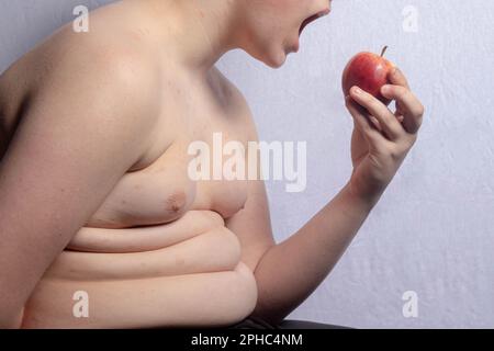 Un ragazzo caucasico in sovrappeso che mangia ananas Foto Stock