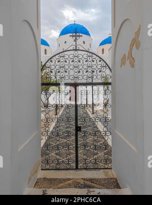 Tradizionale chiesa greca a Perissa, Santorini, Grecia. Chiesa di Santa Croce con cupola blu e campanile Foto Stock