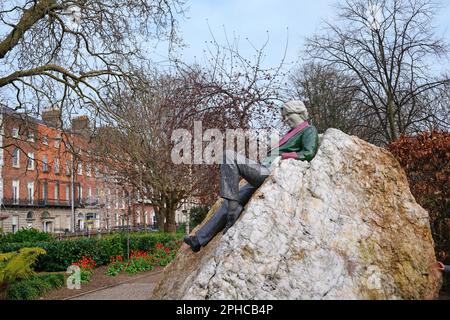 Statua commemorativa di Oscar Wilde di Danny Osborne, sdraiato su una roccia a Merrion Square Park a Dublino, guardando verso la casa dove è nato Foto Stock