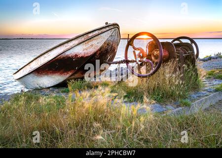 Barca a remi su scivolo con meccanismo di sollevamento lungo la diga Del Ijsselmeer con le nuvole di pioggia di colore rosso che scivola sopra il lago Foto Stock