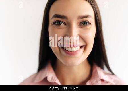 Primo piano ritratto di giovane donna caucasica ritratto casual in vista positiva, sorridente alla macchina fotografica, sfondo bianco Foto Stock