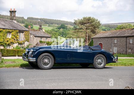 Classic British Jaguar XK150 cabriolet parcheggiato in un villaggio dello Yorkshire in una soleggiata giornata estiva Foto Stock