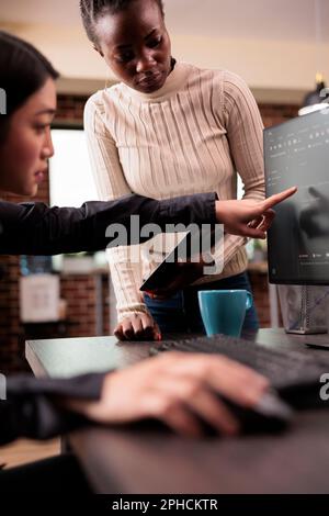 Team di sviluppatori di software che parla di codice sorgente in esecuzione sul computer, lavorando con la finestra del terminale di cloud computing. Ingegneri che lavorano con l'interfaccia utente per sviluppare un nuovo firewall di sicurezza Foto Stock