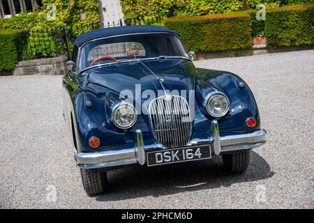 Classic British Jaguar XK150 cabriolet parcheggiato in un villaggio dello Yorkshire in una soleggiata giornata estiva Foto Stock