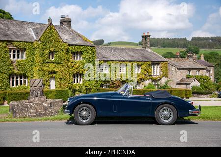 Classic British Jaguar XK150 cabriolet parcheggiato in un villaggio dello Yorkshire in una soleggiata giornata estiva Foto Stock