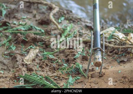 Canne da pesca bloccato nel supporto sul bordo di un fiume, concetto di pesca. Foto Stock