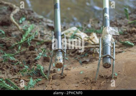 Canne da pesca bloccato nel supporto sul bordo di un fiume, concetto di pesca. Foto Stock